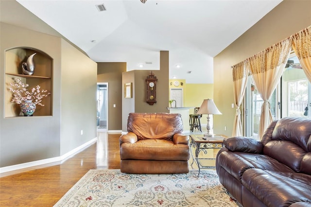 living room with ceiling fan, light hardwood / wood-style flooring, and lofted ceiling