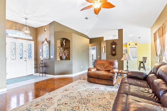 living room with hardwood / wood-style floors, vaulted ceiling, and ceiling fan with notable chandelier