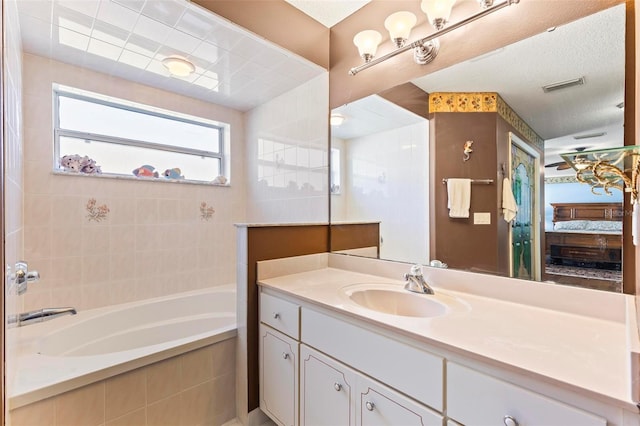 bathroom with tiled bath and vanity