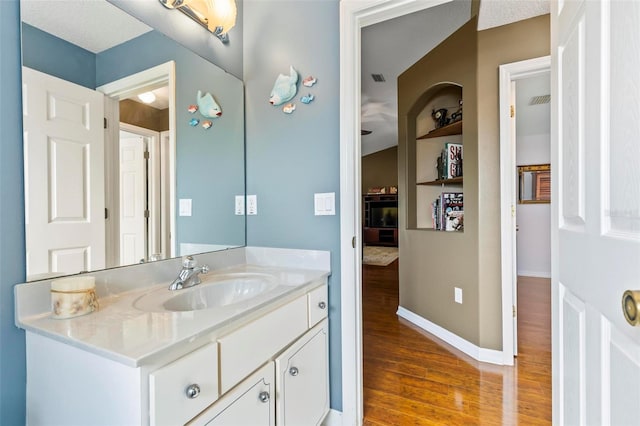 bathroom featuring vanity, hardwood / wood-style flooring, and built in features