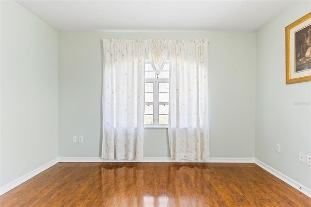 unfurnished room with dark wood-type flooring