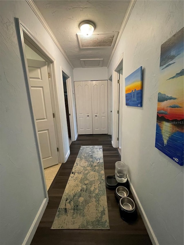 hallway with dark wood-type flooring and crown molding