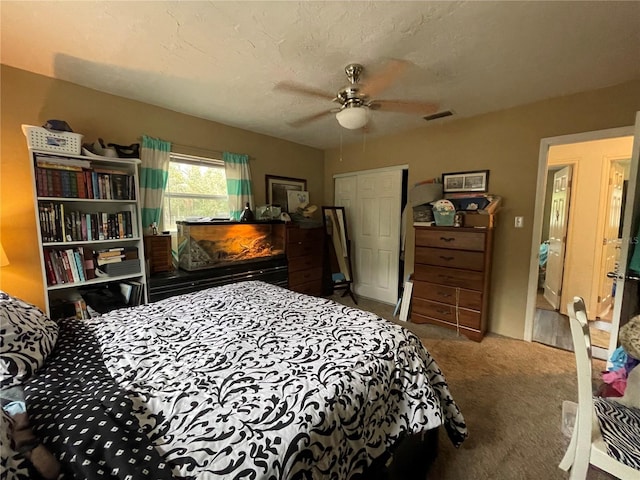 bedroom with a textured ceiling, carpet, and ceiling fan