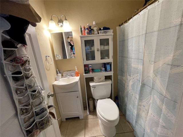 bathroom with toilet, vanity, and tile patterned floors