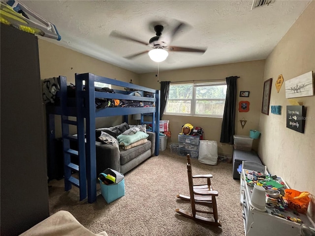 carpeted bedroom featuring a textured ceiling and ceiling fan