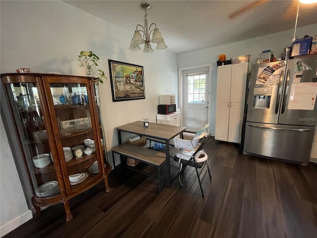 dining area with dark hardwood / wood-style flooring and a notable chandelier