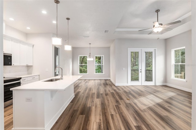 kitchen with plenty of natural light, sink, white cabinetry, and electric stove