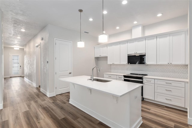 1023 NW 132nd Blvd, Newberry, FL 32669 - kitchen with a sink, white cabinets, a kitchen island with sink, decorative backsplash, and wood finished floors