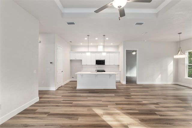 1023 NW 132nd Blvd, Newberry, FL 32669 - kitchen featuring ceiling fan, open floor plan, white cabinetry, baseboards, and a kitchen island with sink
