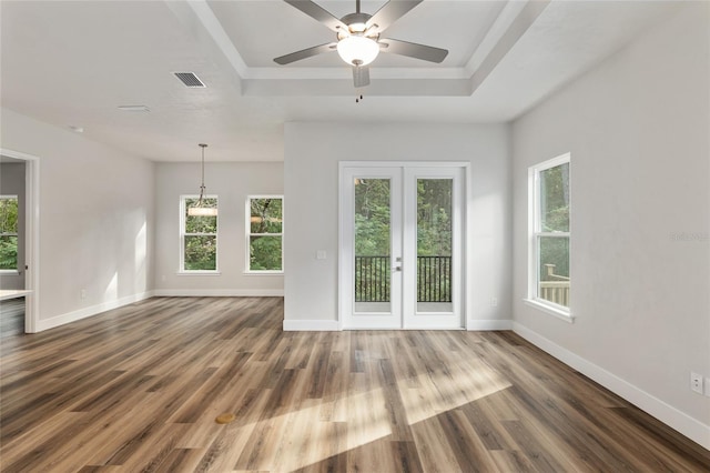 1023 NW 132nd Blvd, Newberry, FL 32669 - empty room featuring a tray ceiling, baseboards, wood finished floors, and a ceiling fan