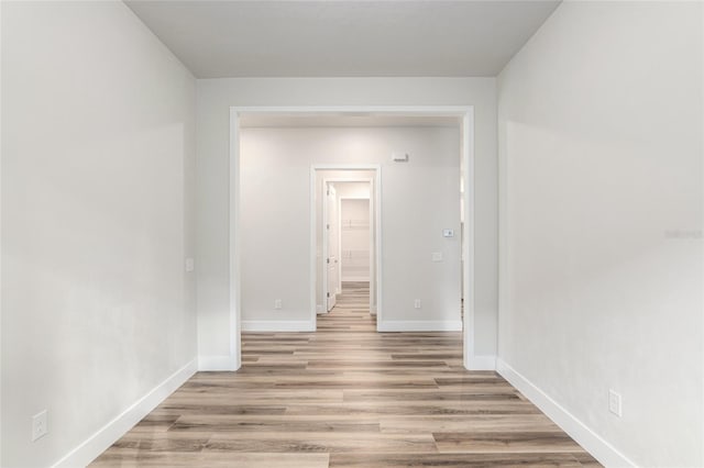 corridor with light hardwood / wood-style floors