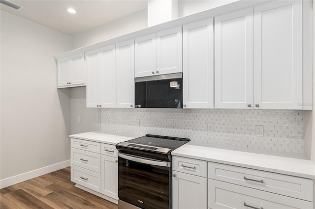 kitchen with light wood-type flooring, white cabinets, backsplash, and stainless steel appliances