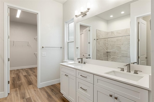 1023 NW 132nd Blvd, Newberry, FL 32669 - full bath with tiled shower, wood finished floors, a walk in closet, double vanity, and baseboards
