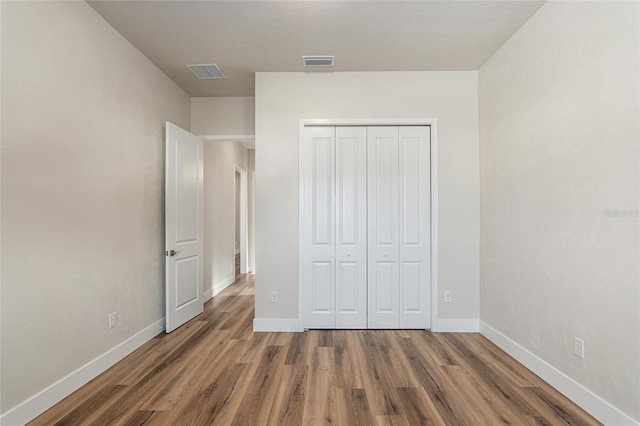 unfurnished bedroom featuring dark wood-type flooring and a closet