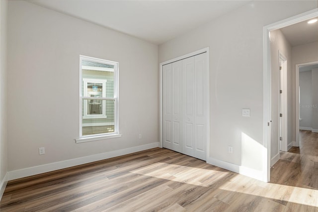 1023 NW 132nd Blvd, Newberry, FL 32669 - unfurnished bedroom featuring wood finished floors, baseboards, and a closet