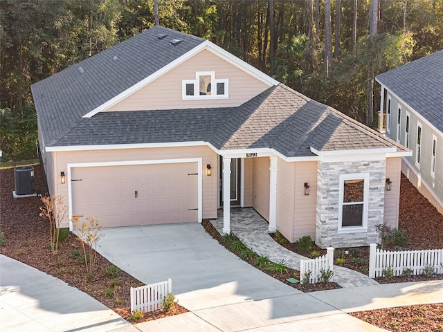 view of front of home with central air condition unit and a garage