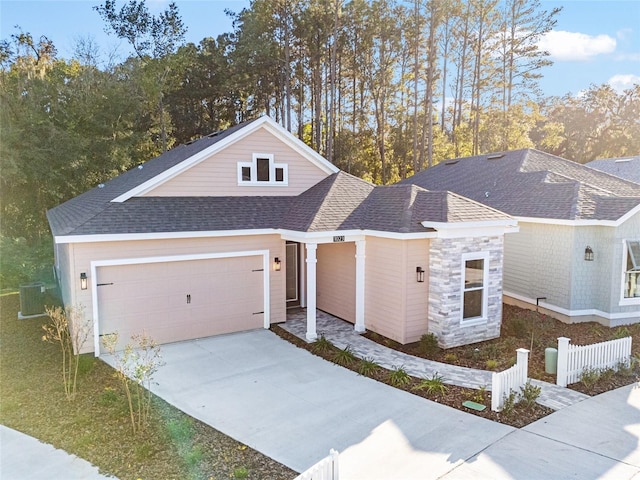 1023 NW 132nd Blvd, Newberry, FL 32669 - view of front facade with an attached garage, driveway, a shingled roof, stone siding, and fence
