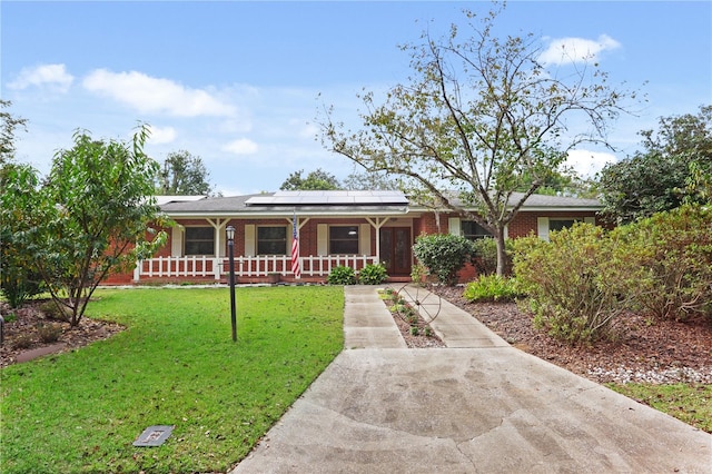 ranch-style home with a front yard, solar panels, and a porch