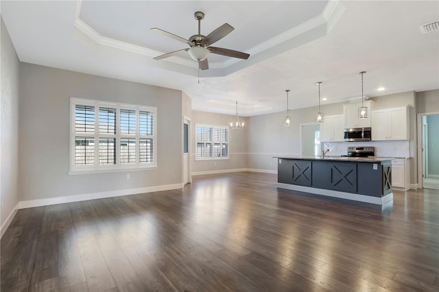 unfurnished living room featuring a raised ceiling and dark hardwood / wood-style flooring