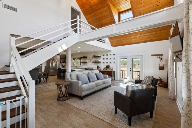 7550 SW 127th Ct, Cedar Key, FL 32625 - living area featuring a towering ceiling, stairs, wood finished floors, wood ceiling, and french doors