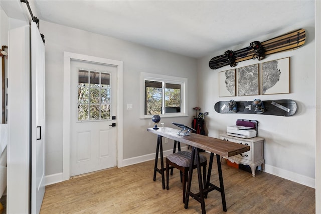 dining space featuring a barn door and light wood-type flooring