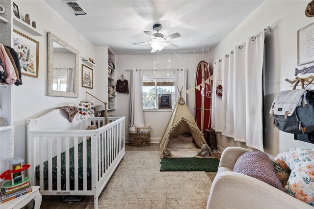 7550 SW 127th Ct, Cedar Key, FL 32625 - bedroom featuring wood finished floors, ceiling fan, and a nursery area