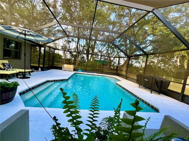 view of swimming pool featuring a patio and a lanai