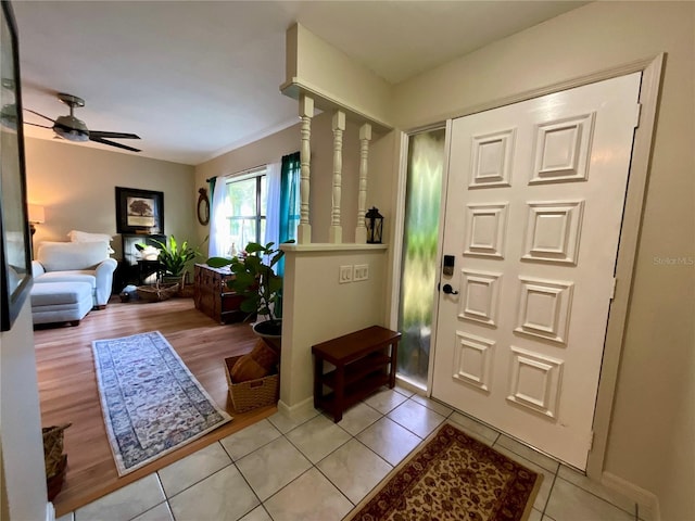 foyer featuring ceiling fan, crown molding, and light hardwood / wood-style flooring