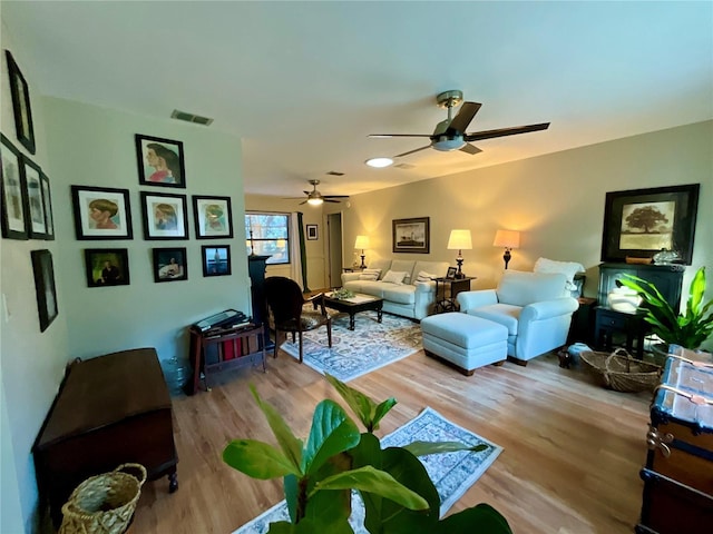 living room with light wood-type flooring and ceiling fan