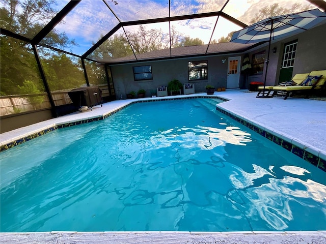 view of pool featuring glass enclosure and a patio