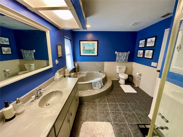 bathroom with a bathing tub, vanity, toilet, and tile patterned flooring