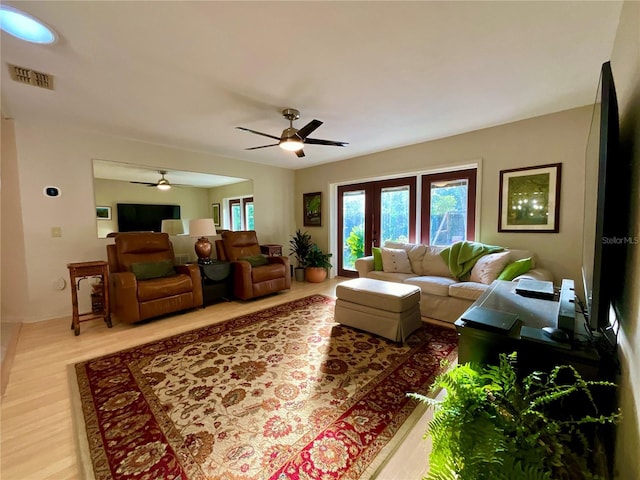 living room featuring wood-type flooring and ceiling fan