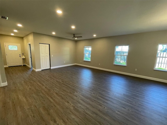 unfurnished living room featuring ceiling fan and dark wood-type flooring