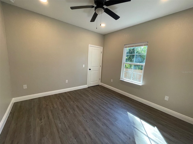 spare room with dark hardwood / wood-style flooring and ceiling fan