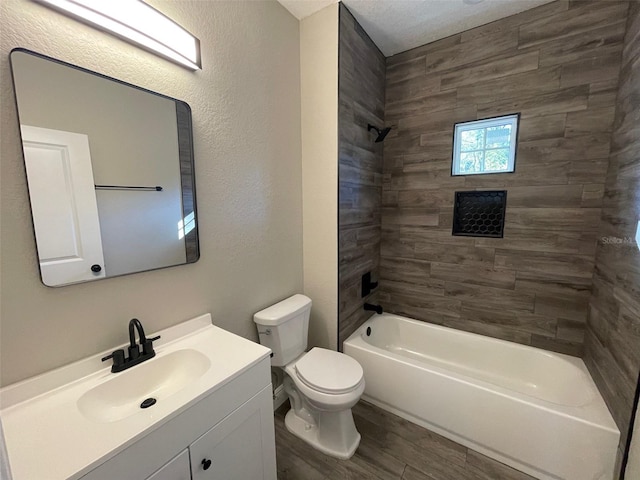 full bathroom with vanity, a textured ceiling, hardwood / wood-style floors, toilet, and tiled shower / bath