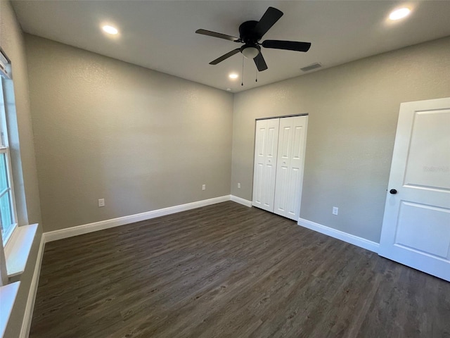 unfurnished bedroom with a closet, ceiling fan, and dark hardwood / wood-style flooring