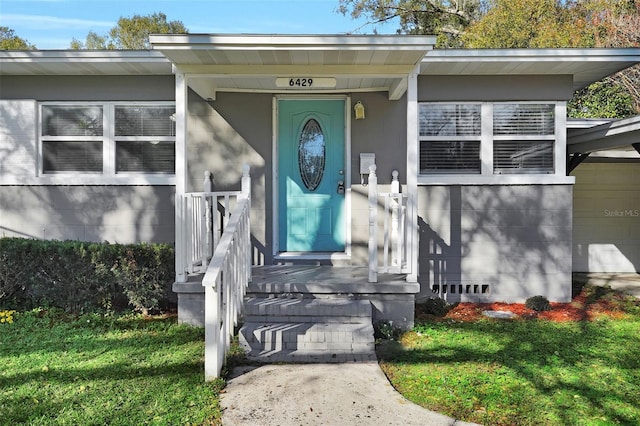 view of exterior entry with a lawn