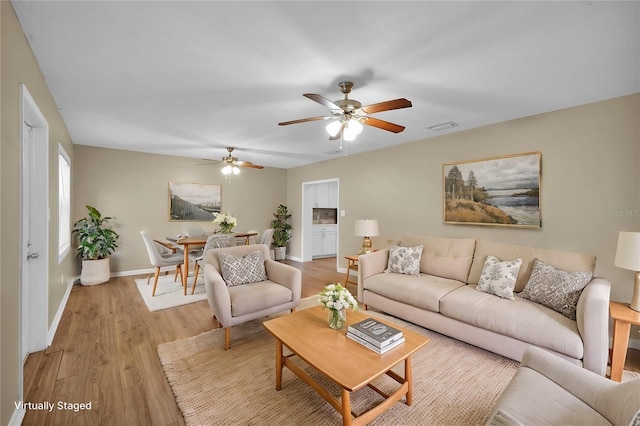 living room with light wood-type flooring and ceiling fan