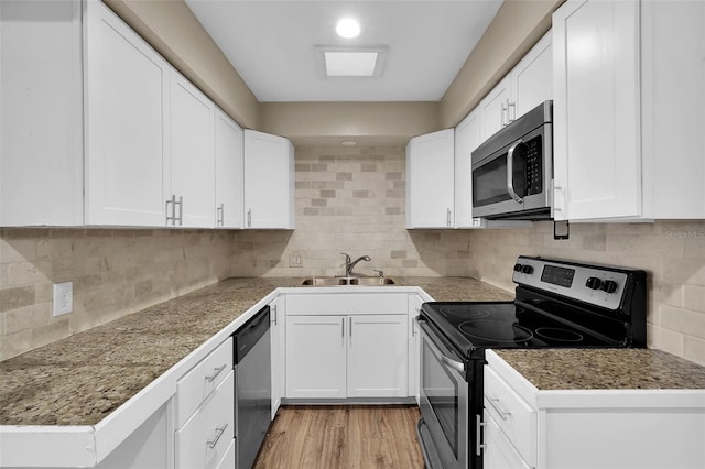 kitchen featuring backsplash, white cabinetry, appliances with stainless steel finishes, and sink