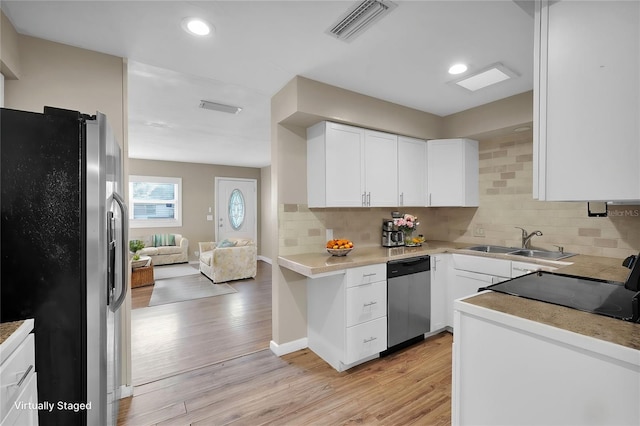 kitchen featuring sink, stainless steel appliances, white cabinets, and backsplash