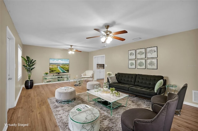 living room featuring light wood-type flooring and ceiling fan