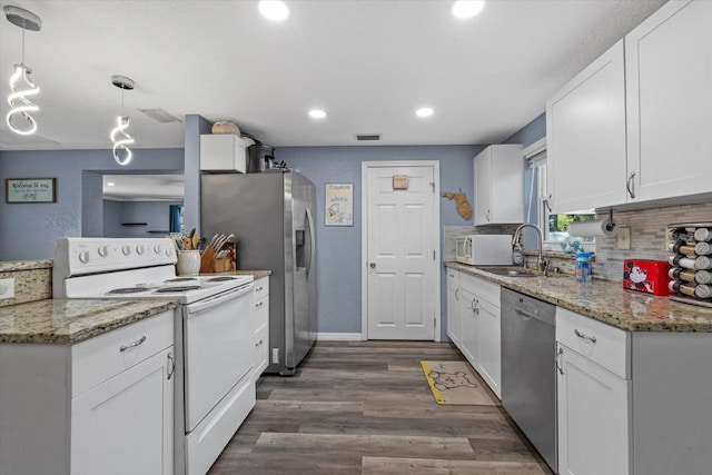 kitchen featuring hanging light fixtures, dark hardwood / wood-style floors, white appliances, decorative backsplash, and white cabinets