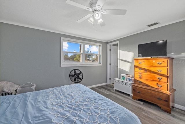 bedroom featuring ceiling fan, dark hardwood / wood-style flooring, and crown molding