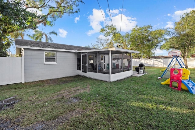 back of property featuring a lawn and a sunroom