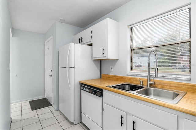 kitchen featuring white dishwasher, sink, white cabinets, and light tile patterned flooring