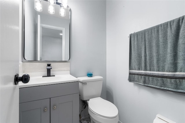 half bathroom with vanity and toilet