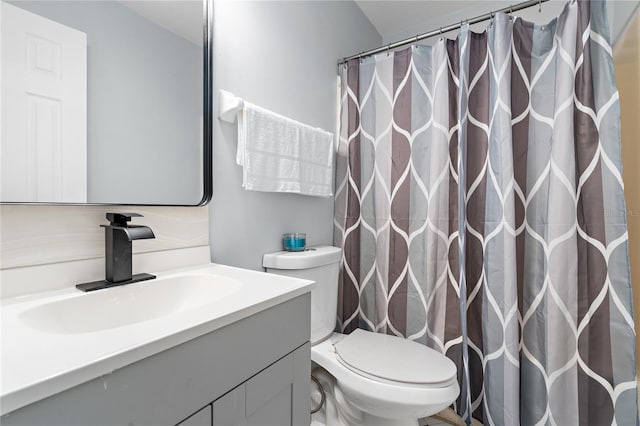 bathroom with toilet, curtained shower, and vanity