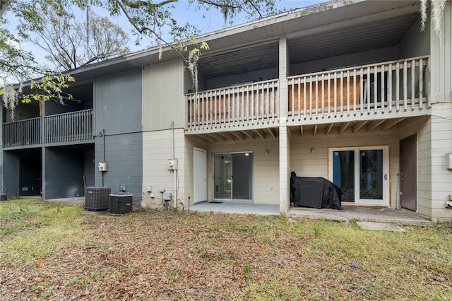 back of property with central AC unit, a patio area, and a balcony