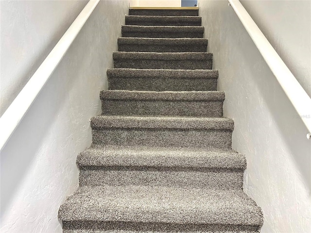 staircase featuring a textured wall