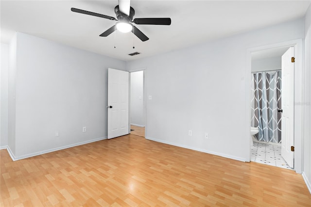 unfurnished room with light wood-style floors, baseboards, visible vents, and a ceiling fan